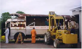 Hi low tractor being used to remove panels of the rusted Futurliner