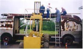 Men working on the top of the rusty Futurliner
