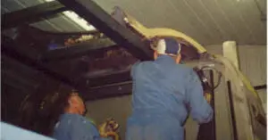 Two men working on the roof of the Futurliner