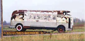 Rusted Futurliner being wheeled off a semi truck bed