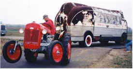 Rusted Futurliner being pulled by a red tractor