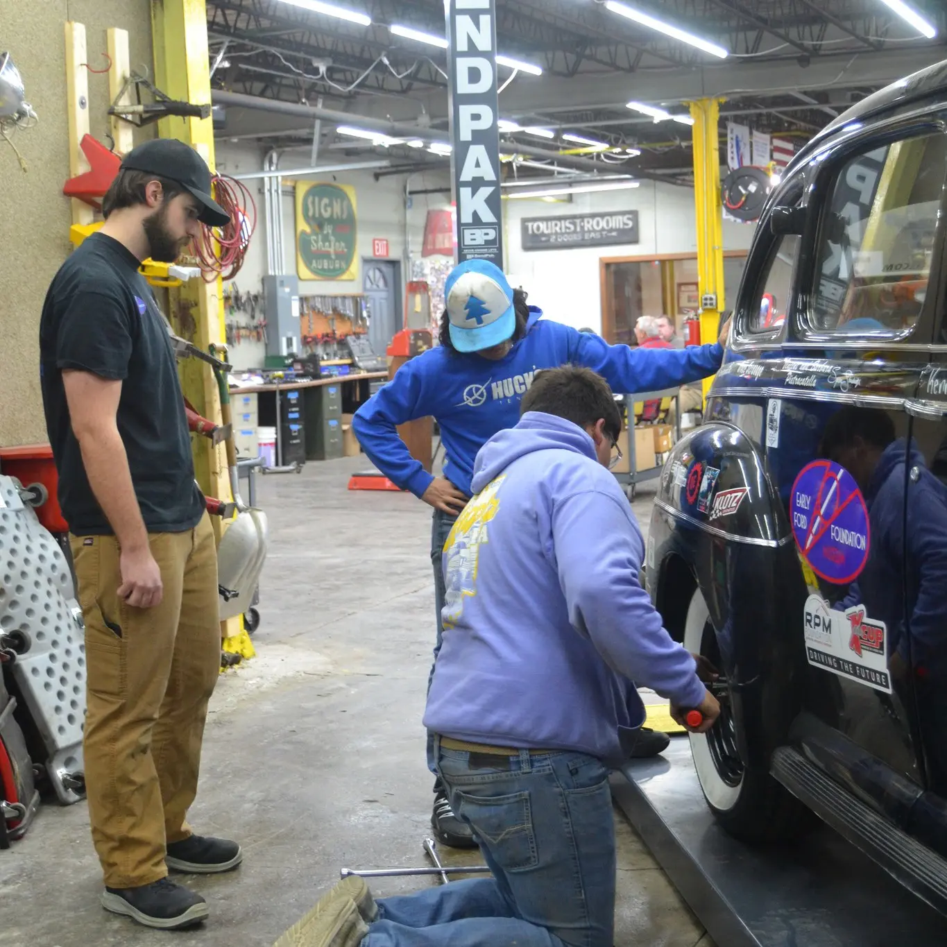 Three volunteers change a tire