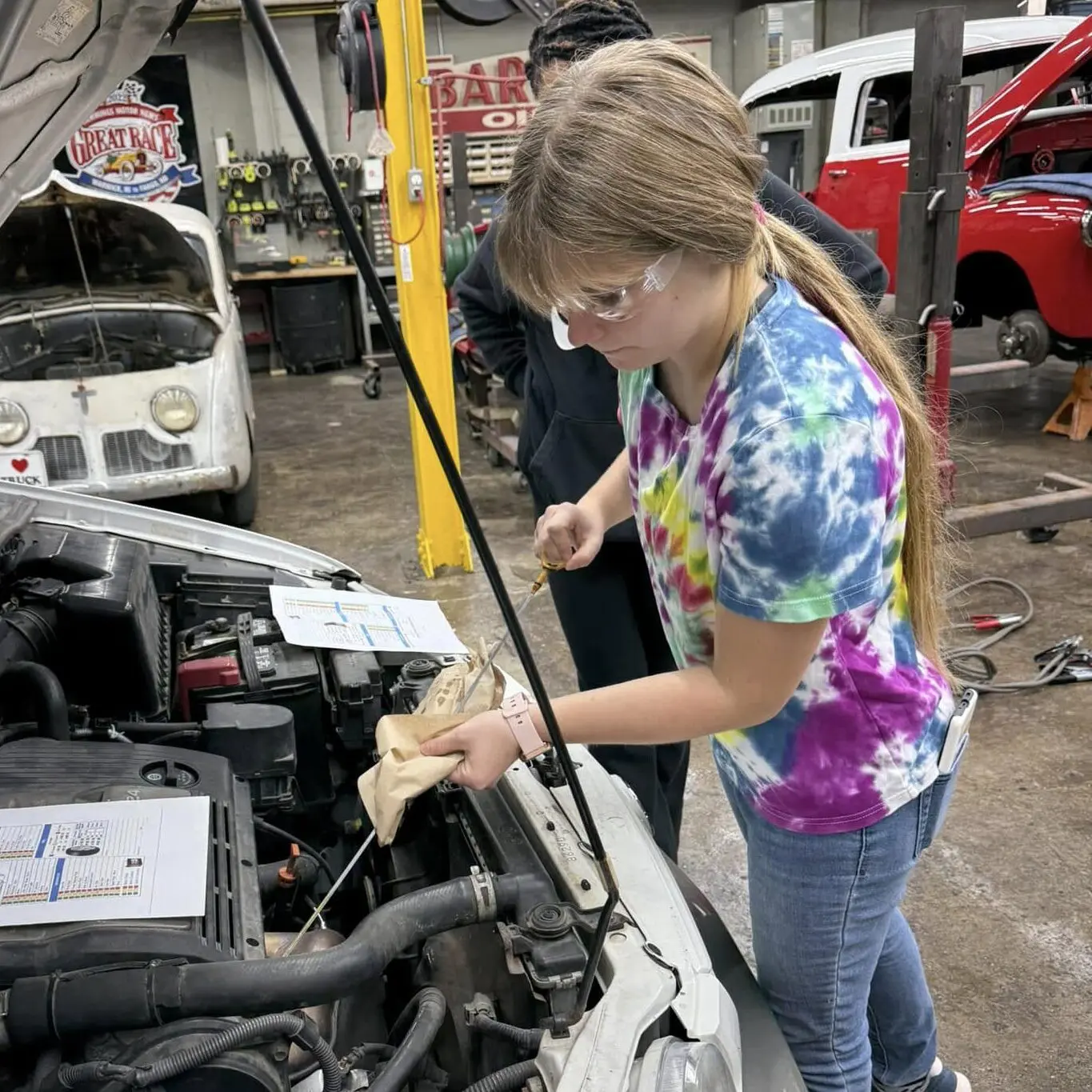 Young woman changes oil on a van